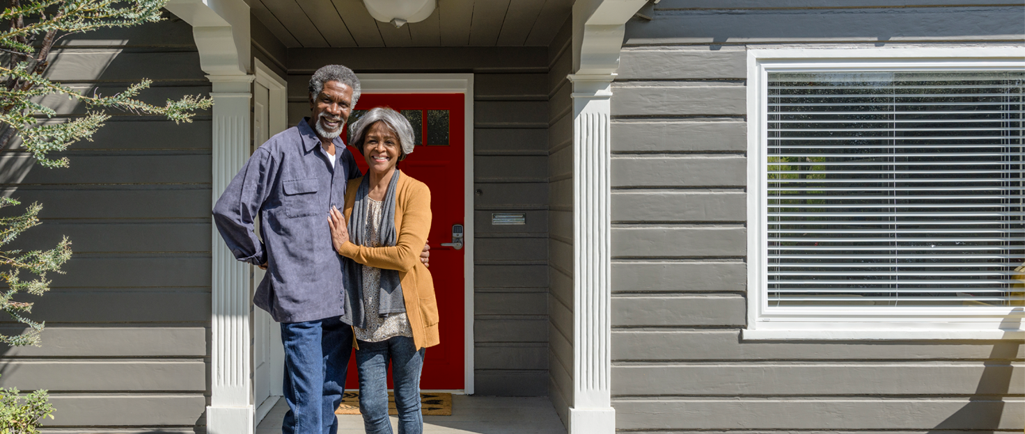 Mature couple on front porch in front of newly redesigned home