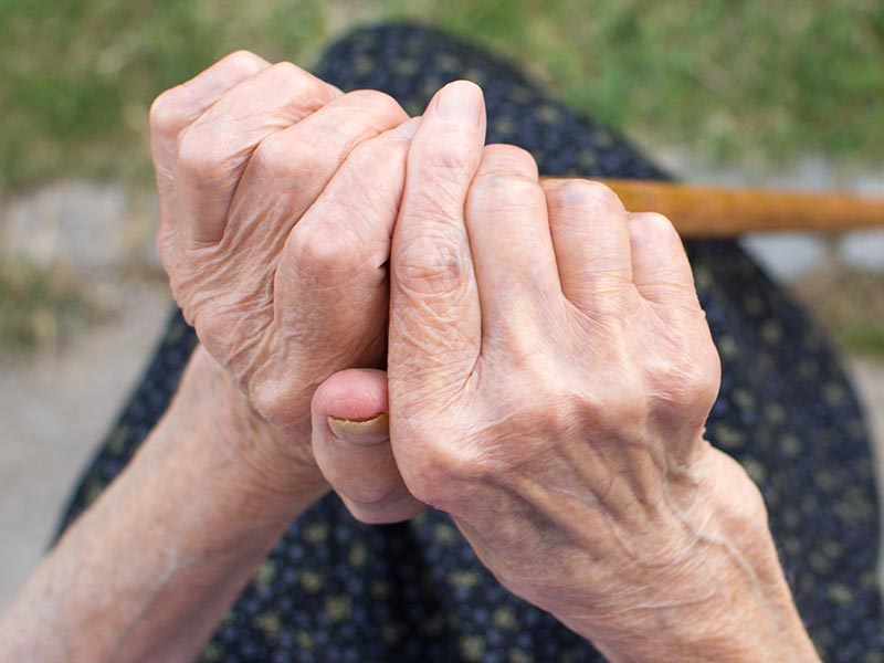 Close up of hands holding cane